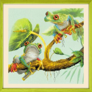 Cross-stitch design of two colorful tree frogs on a branch with a dragonfly and lush green leaves in the background.