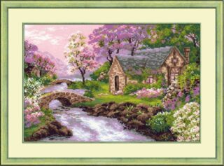 Cross-stitch kit featuring a charming stone cottage surrounded by blooming spring trees and flowers, with a stone bridge over a flowing stream.