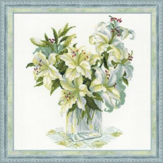 Cross-stitch embroidery of a bouquet of white lilies with green leaves, arranged in a clear glass vase on a patterned cloth. Design from RIOLIS kit 1169 White Lilies.