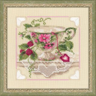 Cross stitch of a floral teacup with pink flowers and green leaves, sitting on lace with raspberries and a heart-shaped tea tag.