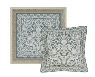 A cross-stitch artwork of an ornate Viennese lace pattern in white on a muted blue-grey background, styled as both a framed panel and a cushion.