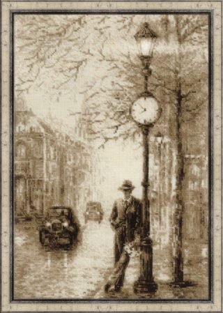 A cross-stitch artwork of a sepia-toned city street with vintage cars, bare trees, and a man in a suit leaning against a lamppost with a clock.