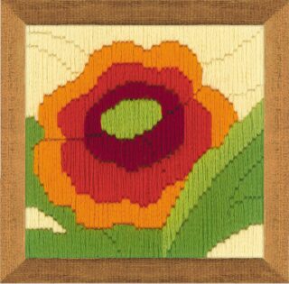 Framed embroidery of a bold red and orange poppy flower with green leaves on a light background.