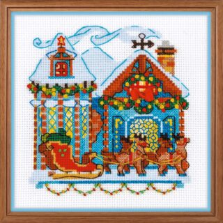 Cross stitch design of a festive cabin with Christmas lights, a sleigh, and reindeer standing in front of the snow-covered house.