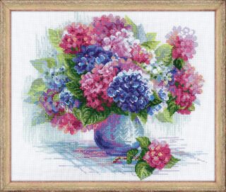 Cross stitch design of a large bouquet of pink, purple, and blue hydrangeas arranged in a glass vase with scattered petals