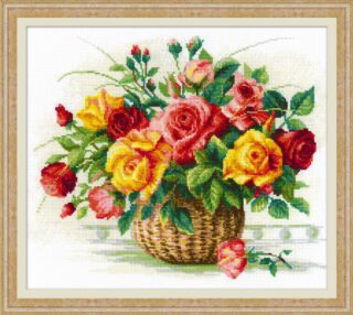 Cross-stitched floral arrangement of red, pink, and yellow roses in a wicker basket with green leaves.