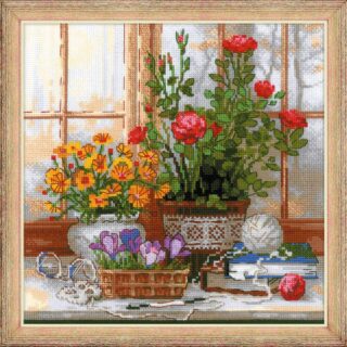 A cross-stitched still life of colorful flowers on a windowsill with books, yarn, and bright natural light.