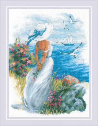 A woman in a flowing white dress and sunhat stands near the sea, holding roses as she gazes at sailboats and flying seagulls.