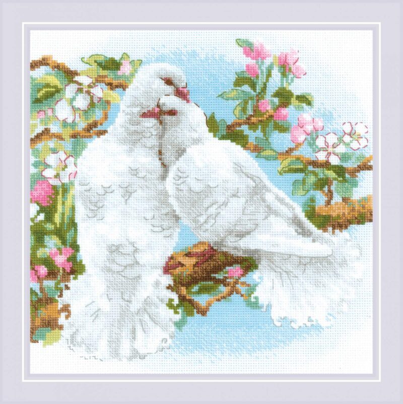 Two white doves sit close together on a blossoming branch against a bright blue sky in this RIOLIS cross stitch design.