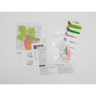 Cross stitch with beads on a bright red strawberry with green leaves and white pearl-like beaded flowers on white fabric.