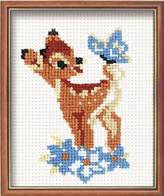 Small cross-stitch design of a young doe with a blue butterfly resting on its tail, surrounded by blue flowers.