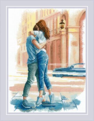 Cross-stitch design of a loving couple embracing on a sunlit city street with soft pastel buildings in the background.
