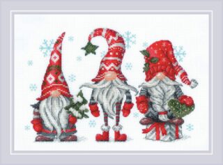Three festive Christmas gnomes in red hats holding holiday decorations with snowflakes falling around them.