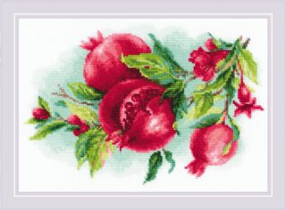 Cross-stitch design of ripe red pomegranates with lush green leaves, featuring a halved fruit showing vibrant seeds.