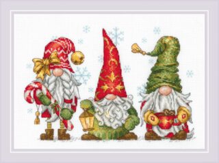 Cross-stitch design showing three festive gnomes in red and green hats, holding a candy cane, lantern, and a mug, with snowflakes falling behind them.