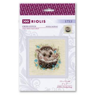 A smiling baby hedgehog sits in tall grass surrounded by bright blue flowers in a charming cross-stitch design.