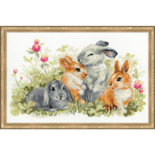 Cross-stitched image of four cute rabbits—two gray and two brown—sitting among green grass and pink clover flowers.