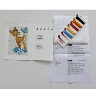 Small cross-stitch design of a young doe with a blue butterfly resting on its tail, surrounded by blue flowers.