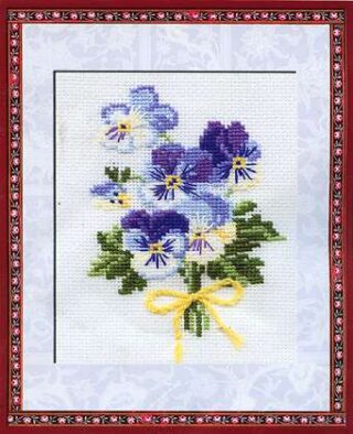 A cross-stitch design of a small bouquet of purple and blue viola flowers with green leaves, tied together with a yellow ribbon.
