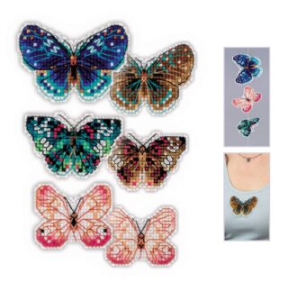 Three colorful cross-stitched butterfly magnets in shades of teal, brown, pink, and orange displayed on a white background.