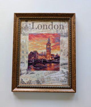Framed embroidery of London’s Big Ben and Westminster at sunset, with the word “London” stitched above and vintage-style background details.