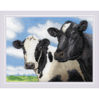 Cross stitch embroidery depicting two cows standing side by side against a bright blue sky with white clouds and green grass in the background. The cow on the left is white with black spots, while the cow on the right is mostly black with a white patch on its forehead. The design is framed in a light lavender border.