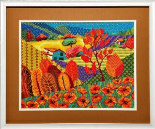 Framed embroidery of a colorful countryside scene with poppy fields, trees in red and orange, hills, and small houses in vivid tones.