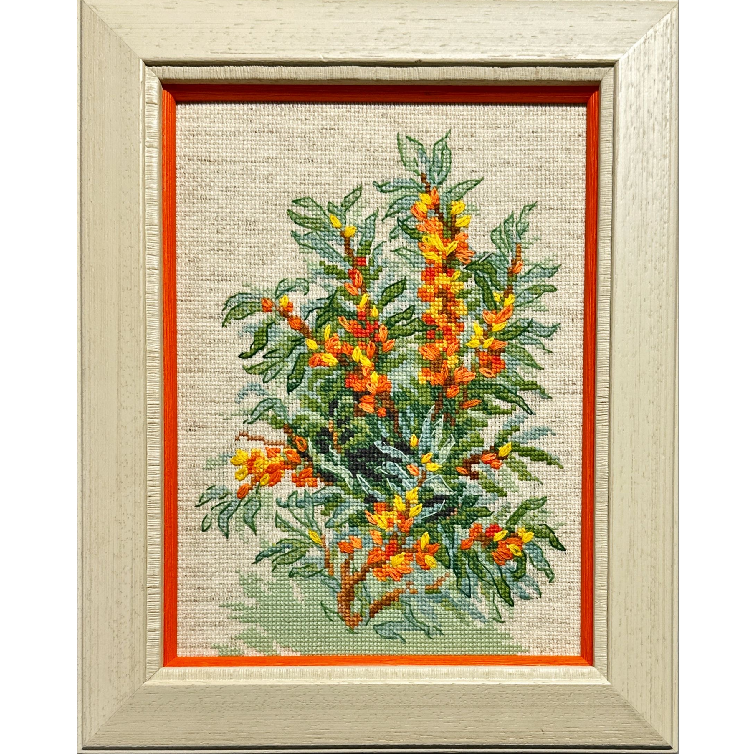 Framed cross-stitch artwork featuring a vibrant blooming shrub with yellow and orange flowers and lush green leaves.