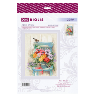 Cross-stitch of a bouquet of colorful garden flowers arranged on a teal chair with two small birds, a spool of thread, and ribbon beside it.
