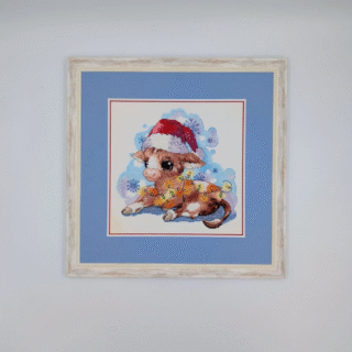 Framed cross-stitch artwork of a cute calf wearing a Santa hat and wrapped in festive lights against a snowy winter background.