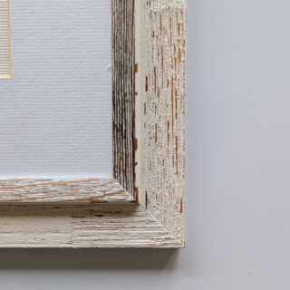 Stitched and framed embroidery artwork featuring a vertical botanical illustration of calendula flowers with yellow-orange blooms and delicate leaves.