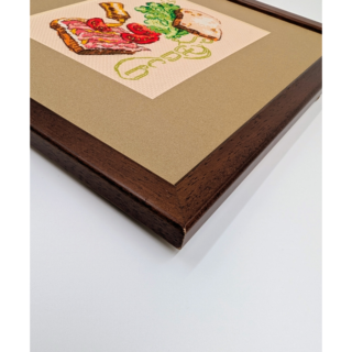 Stitched and framed embroidery artwork depicting an open sandwich with bread, lettuce, tomatoes, and cheese arranged playfully.