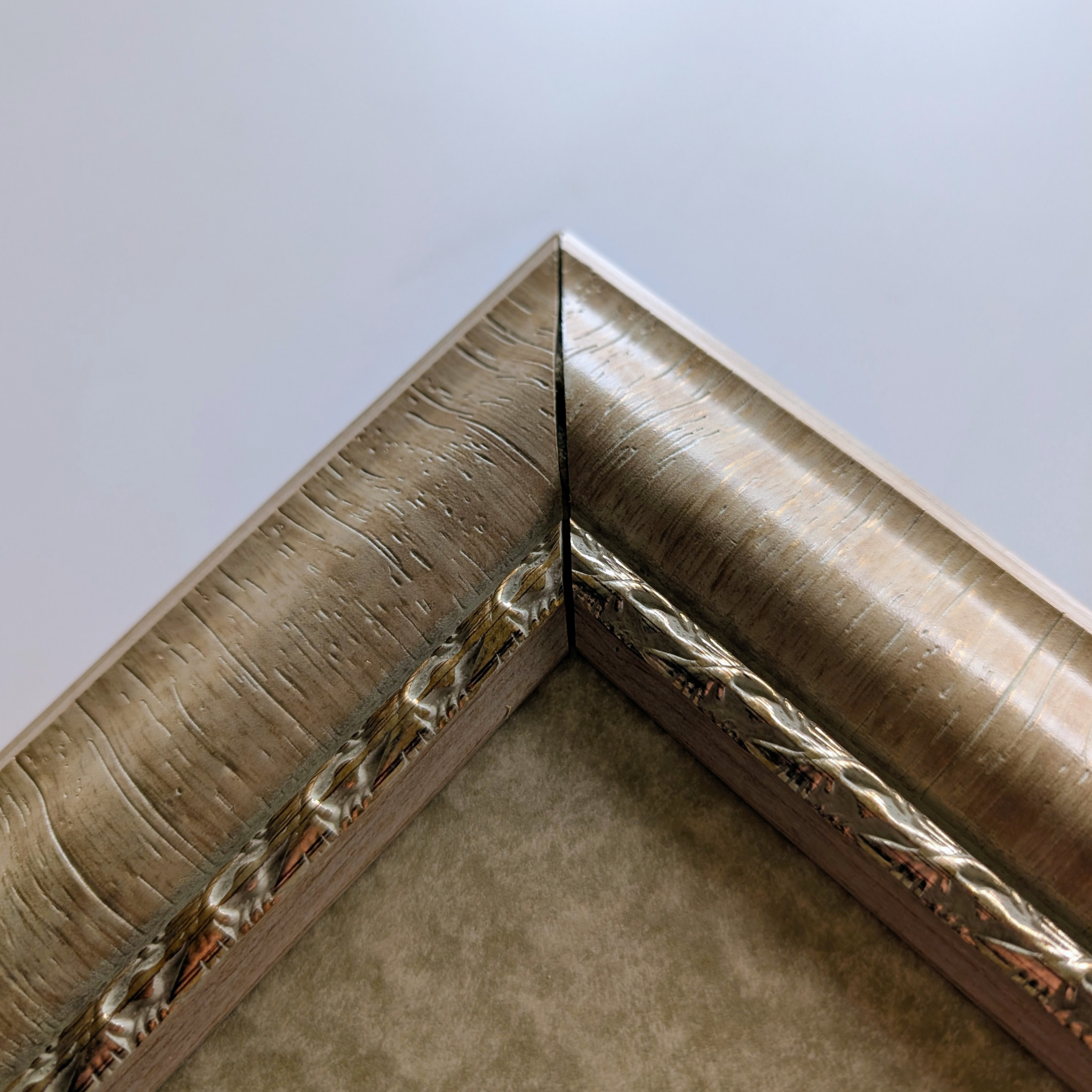 Framed cross-stitch artwork featuring a bouquet of white bellflowers arranged in a purple vase with a delicate ribbon.