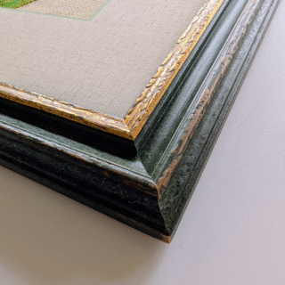 Framed cross-stitch artwork featuring a colorful bouquet of allium flowers in purple, white, and magenta tones.