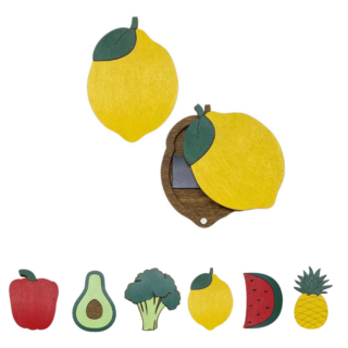Colorful wooden needle cases shaped like fruits and vegetables including lemon, avocado, pepper, broccoli, watermelon, and pineapple.