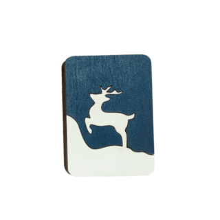 Handcrafted wooden needle case with winter-themed cutout on blue background.