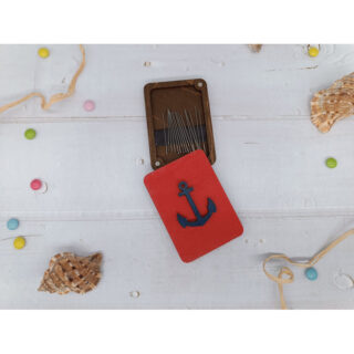 Rectangular wooden needle case with magnetic interiors featuring blue anchor on pastel backgrounds.